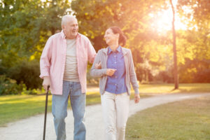 caregiver walking outside with a senior man