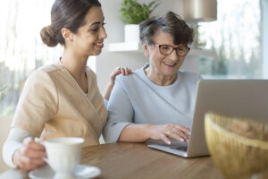 Hampstead caregiver assisting senior lady on computer