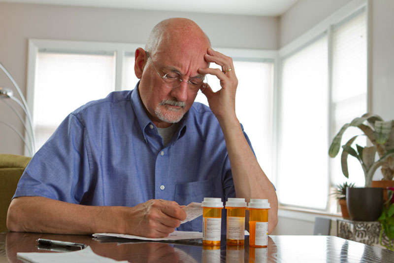 A senior man reviews his medications because certain drugs can cause falls in older adults.